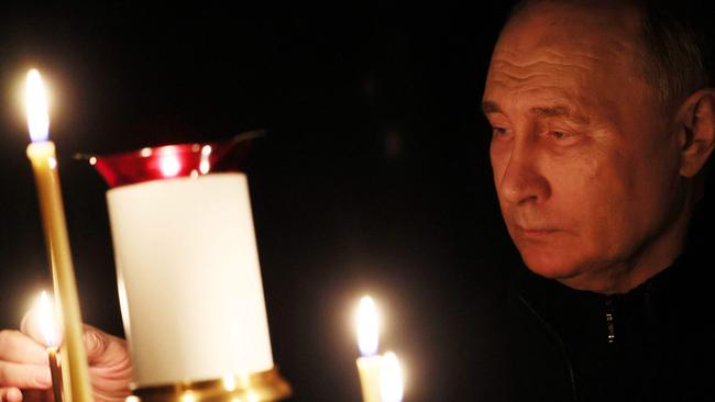 President Vladimir Putin lights a candle during his visit to a church on the national day of mourning. Picture: Mikhail METZEL / POOL / AFP