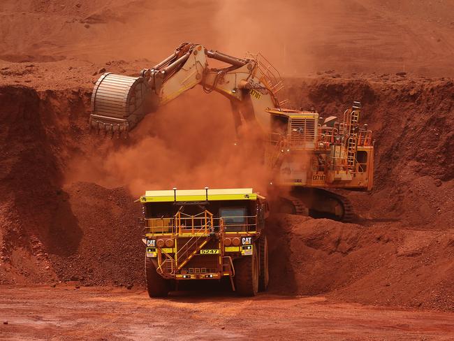 An excavator loads ore into an autonomous dump truck at Fortescue Metals Group Ltd.'s Solomon Hub mining operations in the Pilbara region, Australia, on Thursday, Oct. 27, 2016. Shares in Fortescue, the world's No. 4 iron ore exporter, have almost trebled in 2016 as iron ore recovered, and the company cut costs and repaid debt. Photographer: Brendon Thorne/Bloomberg via Getty Images