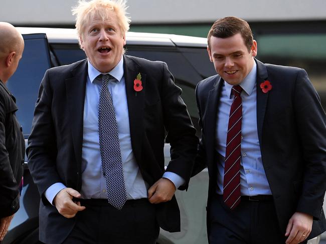 (FILES) In this file photo taken on November 07, 2019 Britain's Prime Minister Boris Johnson (C) is greeted by Conservative party candidate for Moray, Douglas Ross (R) as he arrives for a general election campaign visit to Diageo's Roseisle Distillery near Elgin, north east Scotland. - British Prime Minister Boris Johnson's government suffered its first resignation over the controversy surrounding senior aide Dominic Cummings' trip across country during coronavirus lockdown when Douglas Ross, a minister for Scotland, quit in protest on Tuesday. (Photo by Daniel LEAL-OLIVAS / POOL / AFP)