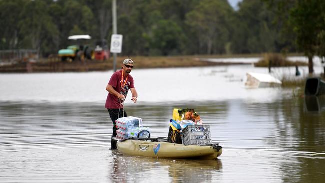 A man uses a kayak to deliver supplies to a flood-affected property on March 7 in Coraki. Picture: Dan Peled/Getty Images