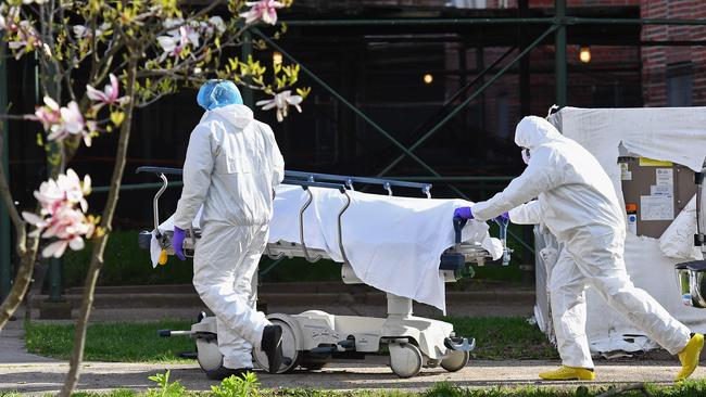 Medical personnel move the body of a deceased patient from a refrigerated truck to Kingsbrook Jewish Medical Center in Brooklyn, New York. Picture: AFP