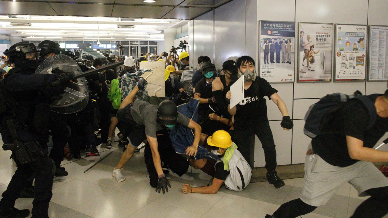 Special Tactical Squad officers use batons to attack protesters who refused to disperse from a train station in Yuen Long district in Hong Kong on Saturday.