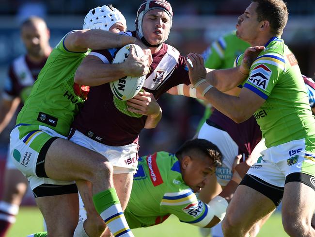 Jamie Buhrer of the Sea Eagles is tackled by Jarrod Croker , (left), and Aidan Sezer of the Raiders during the round 25 NRL match between the Manly-Warringah Sea Eagles and the Canberra Raiders at Brookvale Oval in Sydney, Saturday, Aug. 27, 2016. (AAP Image/Dan Himbrechts) NO ARCHIVING, EDITORIAL USE ONLY