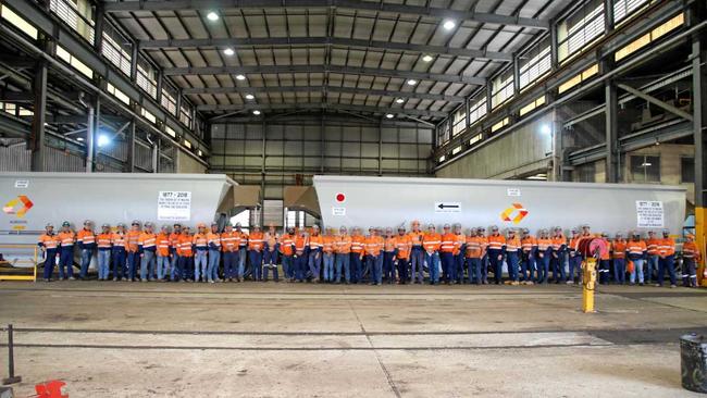 END OF THE LINE: Aurizon employees with the last wagons to be overhauled at the Rockhampton rollingstock workshops.