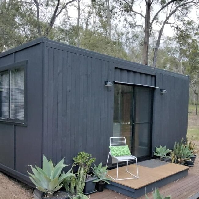 This tiny house is constructed from a 20ft Hi-cube container and features repurposed rough sawn timber cladding.