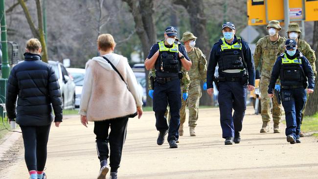 Victoria Police and members of the ADF patrol a popular running track around Melbourne's Botanical Gardens as new rules for mandatory masks come into effect. Picture: Mark Stewart