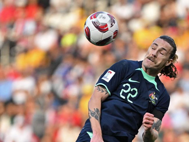 Australia's midfielder #22 Jackson Irvine heads the ball during the Qatar 2023 AFC Asian Cup Group B football match between Syria and Australia at the Jassim bin Hamad Stadium in Doha on January 18, 2024. (Photo by HECTOR RETAMAL / AFP)