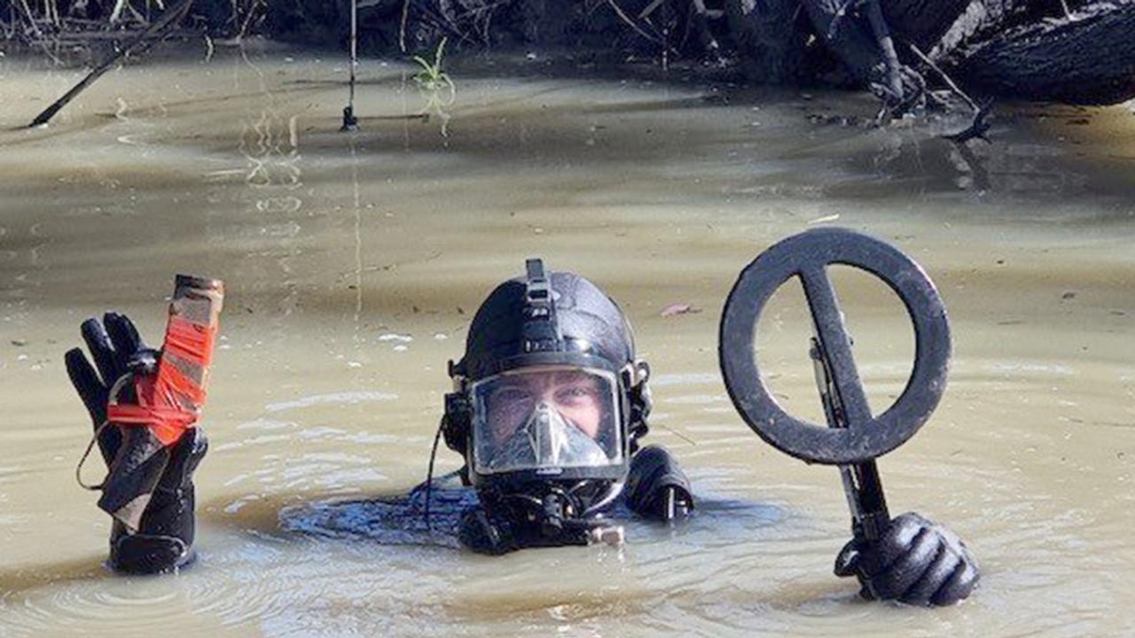 Police with the firearm found in the Condamine River.