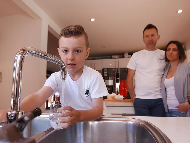 Jackson Halliday, with parents Laura and John, grabs a glass of water from the tap. Picture: Sam Ruttyn