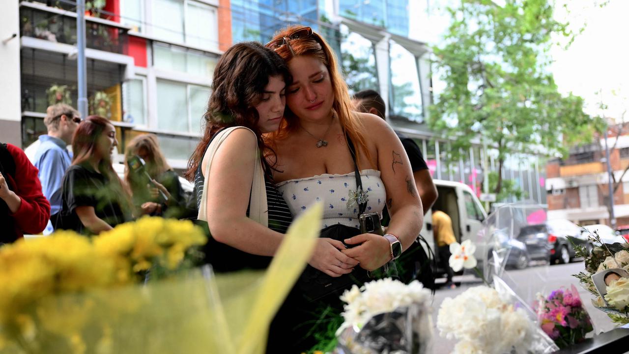 Two young women embrace outside the hotel. Picture: Luis Robayo/AFP