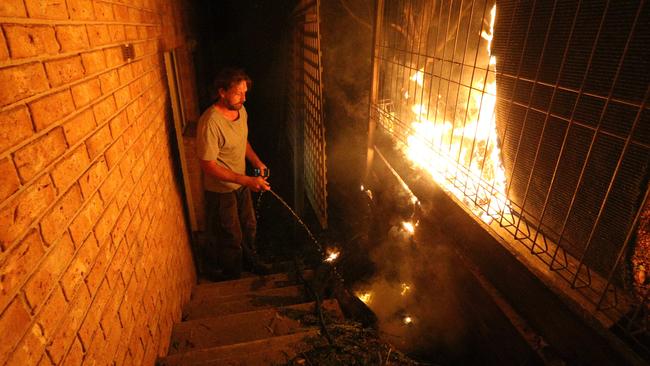 Tathra resident Julian Brown, fights a spot fire at his Dilkera Rd home. Picture: Gary Ramage