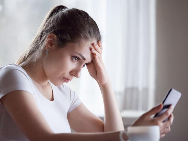Angry young woman looking at smartphone frustrated by no signal or scam message, mad female disappointed by bad news reading on phone, upset girl get negative or rejection response on mobile; generic scam