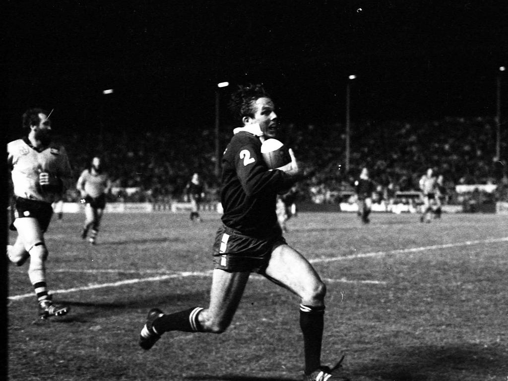 Queensland winger Kerry Boustead races down the sideline to score one of his three tries.