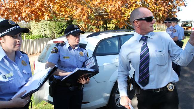 Detective Murray Caine (RHS) prepares to conduct a door knock on Shale Road after a 12 year old girl was abducted and sexually assaulted at Latrobe