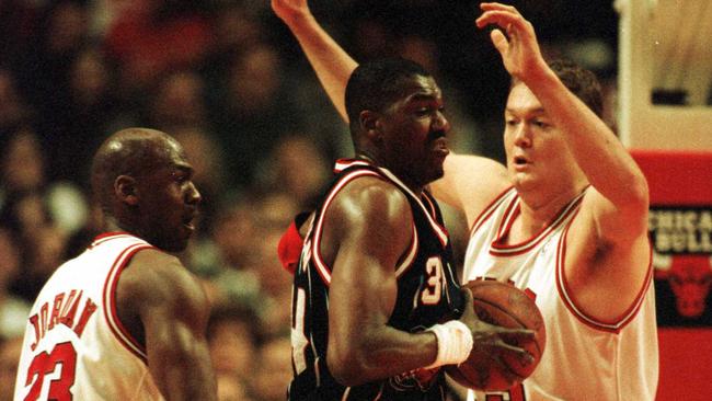 Michael Jordan and Luc Longley guard Hakeem Olajuwon. Picture: Jonathan Daniel/AL