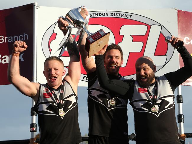 (L - R) Captain Harley Short and playing coach Michael Farrelly of Roxburgh Park with team mate Osama Saad celebrate with the trophy after EDFL Division 2 grand final. Picture: Hamish Blair