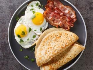 Delicious oatcakes served with egg and bacon close-up in a plate on the table. horizontal top view from above