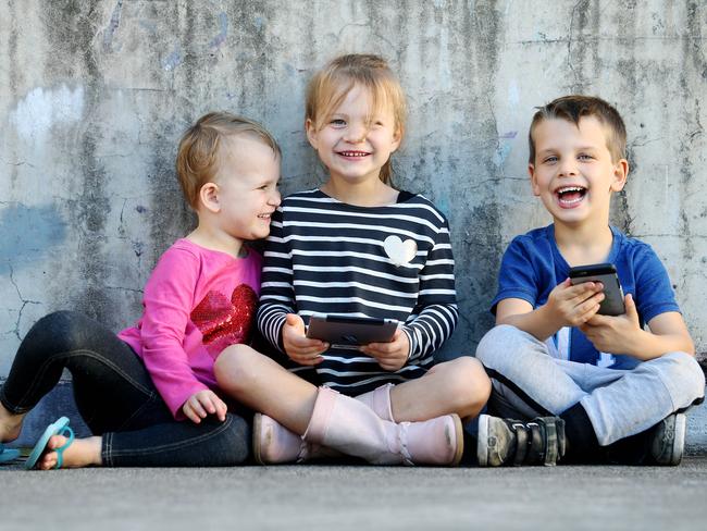 Ellie Newton, 3, Dylan Newton, 6, and Max Wilson, 4, enjoy playing on their iPads and iPhones. Pics Tara Croser.