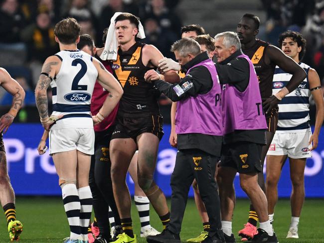 GEELONG, AUSTRALIA - JULY 06: Mitch Lewis of the Hawks leaves the field with trainers after hurting his knee and receiving head contact during the round 17 AFL match between Geelong Cats and Hawthorn Hawks at GMHBA Stadium, on July 06, 2024, in Geelong, Australia. (Photo by Daniel Pockett/Getty Images)