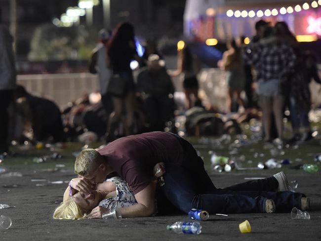 A man lays on top of a woman as others flee the Route 91 Harvest country music festival grounds after a shooting occurred on October 1, 2017 in Las Vegas, Nevada. Picture: David Becker/Getty Images/World Press Photo