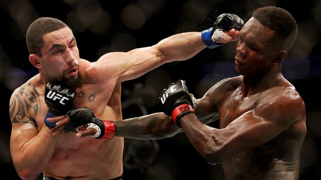 HOUSTON, TEXAS - FEBRUARY 12: Robert Whittaker of Australia punches Israel Adesanya of Nigeria in their middleweight championship fight during UFC 271 at Toyota Center on February 12, 2022 in Houston, Texas. (Photo by Carmen Mandato/Getty Images)