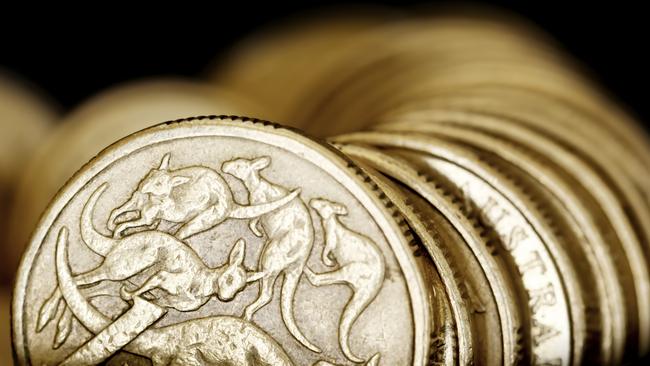 Australian one dollar coins over black background.