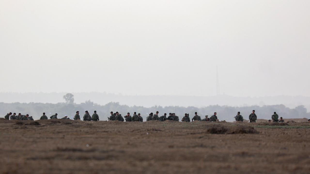 Israeli troops gather near the border with Gaza before entering the Palestinian strip on Saturday. Picture: AFP