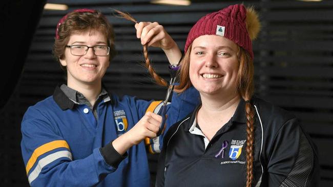 CRUCIAL CUTS: Bremer State High School student and brain cancer survivor Kieran McLeod prepares to cut off the hair of teacher Elizabeth Ricketts to raise money for Beanies for the Cure Brain Cancer Foundation. Picture: Rob Williams