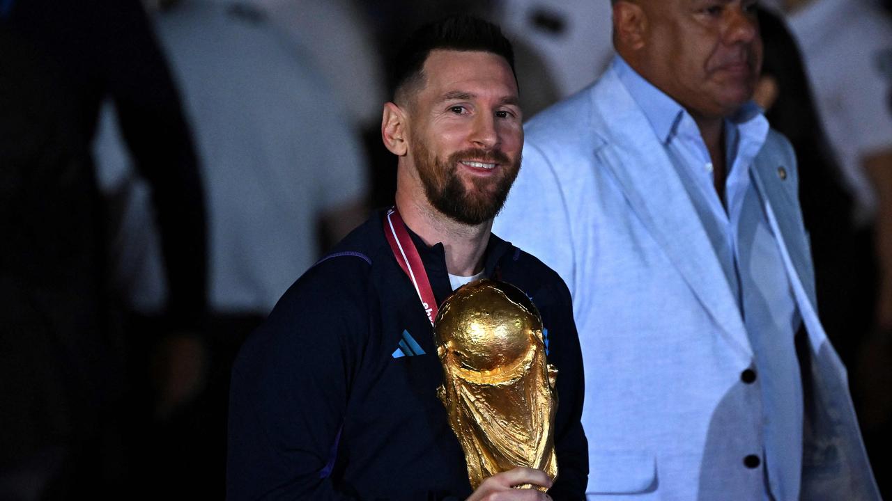Argentina's captain and forward Lionel Messi holds the FIFA World Cup Trophy.