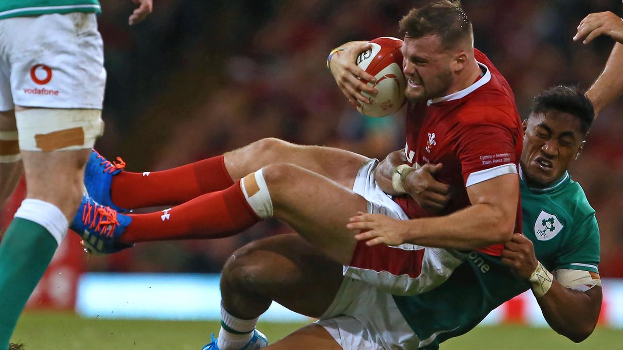 Wales winger Owen Lane is tackled by Ireland centre Bundee Aki.