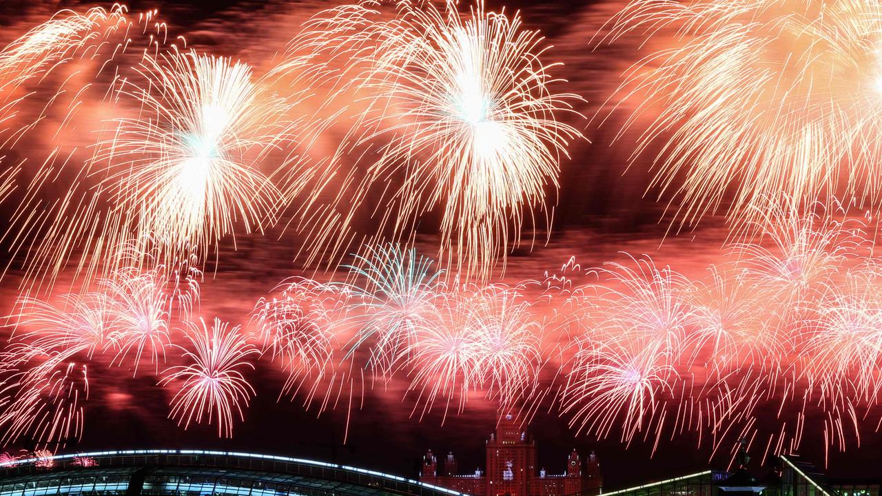 Fireworks explode above a city. (Photo by STRINGER / AFP)