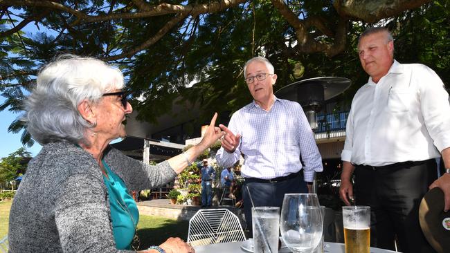 Local resident Toni Lea (left) gestures towards Prime Minister Malcolm Turnbull (centre) and LNP candidate for Longman Trevor Ruthenberg (right) at the Sandstone Point Hotel at Sandstone Point, Queensland, Friday, July 27, 2018. (AAP Image/Darren England) NO ARCHIVING