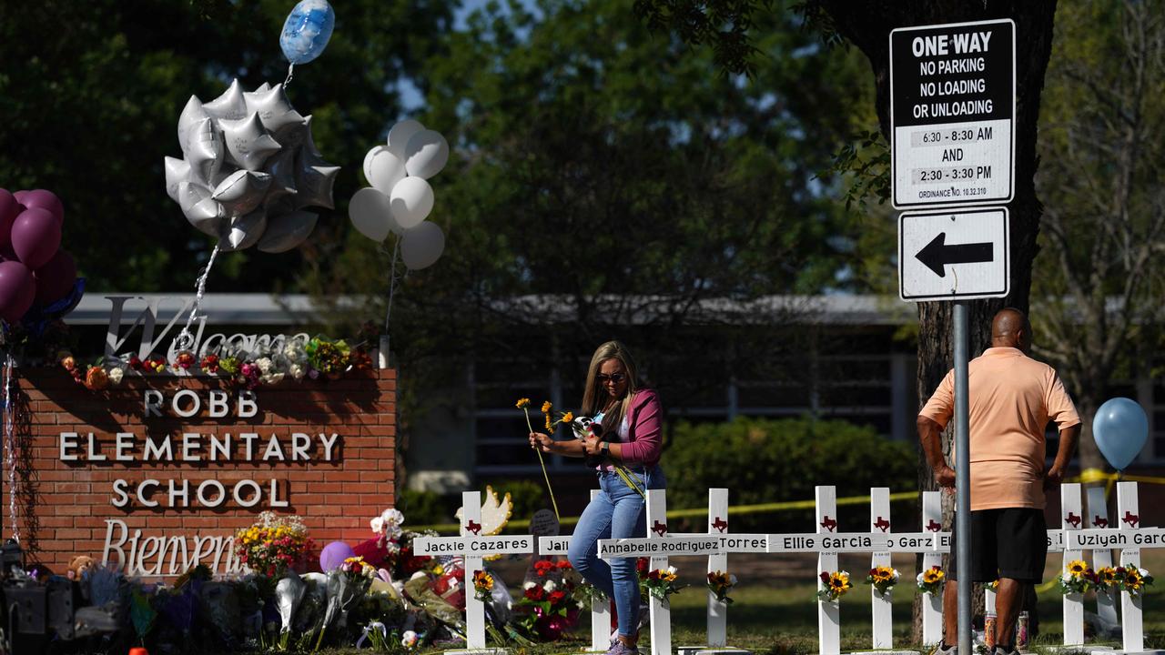 People drop off flowers at a makeshift memorial outside the Robb Elementary School in Uvalde, Texas. (Photo by allison dinner / AFP)