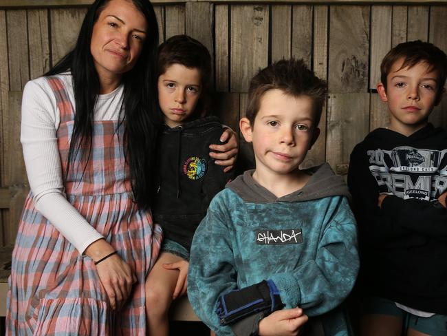 Malu Hunt (centre) with mum Erin and his brothers Harlan and Jarvie. Malu Hunt has had funding cut from NDIS support and his family feels disappointed they will either have to cut his hours of therapy or continue fighting for more support. Picture: Alan Barber