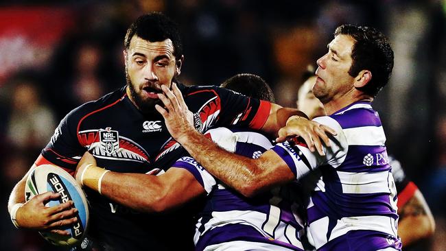 Warrior Ben Matulino of the Warriors charges into Storm’s Cameron Smith and Kenny Bromwich.