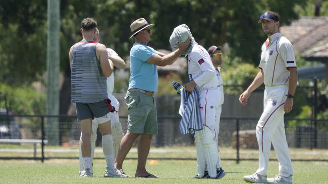 Mordialloc batter Ryan Morris has a cold towel put on his head in Cricket Southern Bayside on Saturday. Picture: Valeriu Campan