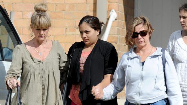 Sofina Nikat (centre) is helped from the Heidelberg West house by social workers as police were still hunting her daughter’s killer. Picture: Andrew Henshaw