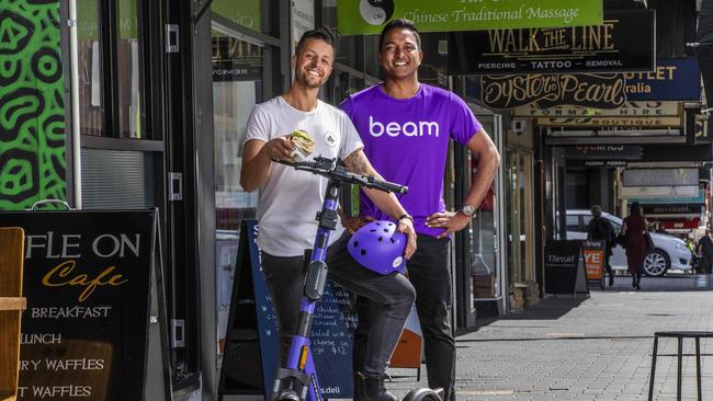 St. J's Deli owner Ben Korkmaz and Beam operations manager Sura Kumar as part of the e scooter trial at Hobart. Picture: Chris Kidd