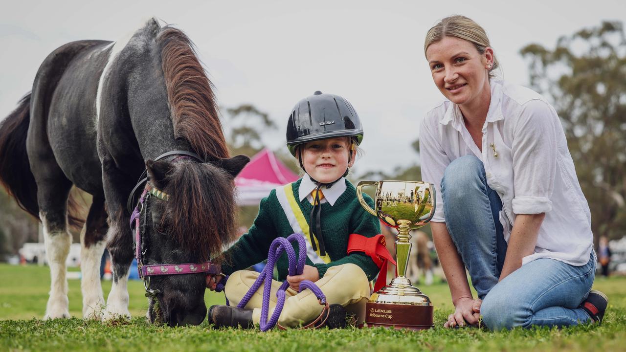 Jockey Jamie Kah shows six-year-old Elanore Bourchier the Melbourne Cup trophy at the Nathalia Ag Show last month. Picture: Nicole Cleary