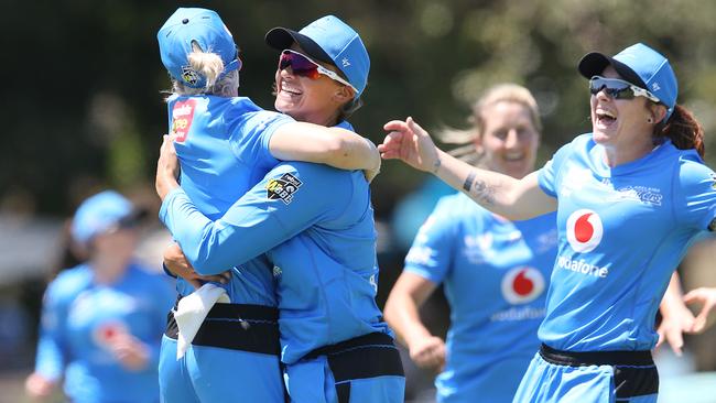 Suzie Bates (right) wraps up Katie Mack in a celebratory hug after Mack took the crucial catch to send Nicola Carey back to the stands and seal the Strikers’ three-run win over the Hobart Hurricanes in Brisbane. Picture: JONO SEARLE/GETTY IMAGES