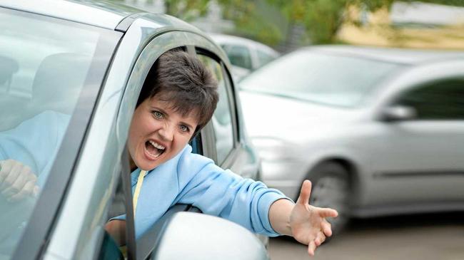 Young Woman Driver Yelling and Shaking her Wrist out Car Window. Picture: AlexanderNovikov