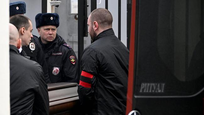 A police officer looks on as pallbearers carry the coffin. Picture: AFP