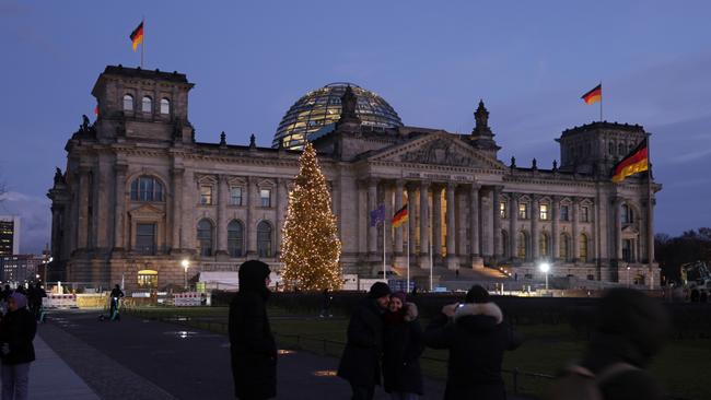 Visitors snap photos of one another outside the Reichstag, seat of the Bundestag, Germany's parliament. Picture: Sean Gallup/Getty Images