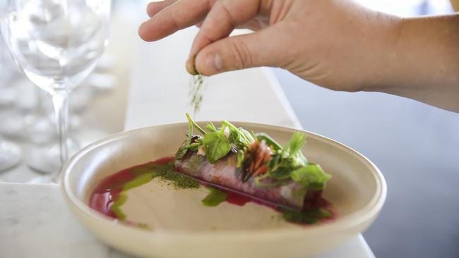 Stokehouse chef Richard Ousby sprinkling lemon myrtle over Tuna Cerviche with native succulents and grapefruit dressing. Picture: Mark Cranitch