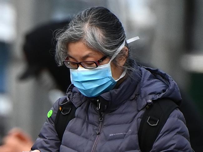 MELBOURNE, AUSTRALIA - JULY 20: A woman wearing a face mask walks through the city on July 20, 2020 in Melbourne, Australia. Victoria has recorded 275 new cases of coronavirus, and another death overnight. The death of the woman in her 80s brings the total number of deaths linked to COVID-19 in the state to 39. Metropolitan Melbourne and the Mitchell shire remain in lockdown due to the rise in COVID-19 cases through community transmissions, with residents in lockdown areas under stay at home orders until 19 August. People are only able to leave home have for exercise or work, to buy essential items including food or to access childcare and healthcare. Face masks or coverings will be mandatory from Thursday 23 July, with $200 fines to apply for not wearing face coverings.  (Photo by Quinn Rooney/Getty Images)