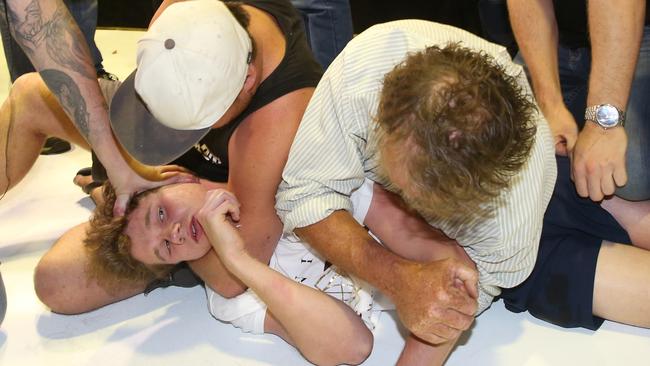 Supporters hold down ‘egg boy’ activist Will Connolly after he smashed an egg over Senator Fraser Anning’s head in Moorabbin on Saturday. Picture: AAP