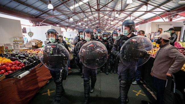 Riot police walking down the aisles of Queen Victoria Market. Picture: Darrian Traynor/Getty Images