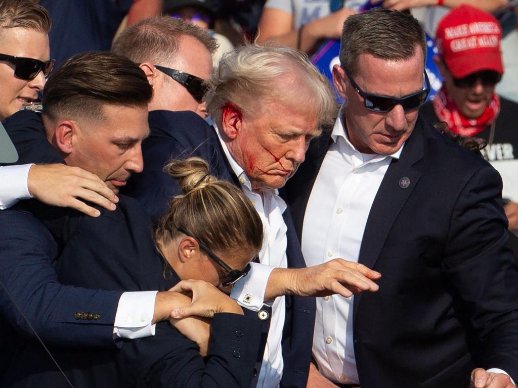 US Republican candidate Donald Trump is seen with blood on his face surrounded by secret service agents after an assassination attempt in Butler, Pennsylvania on 13 July. Picture: AFP