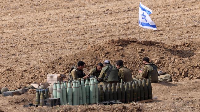 Israeli soldiers take a break as they hold a position along the Israel-Gaza border. Picture: AFP