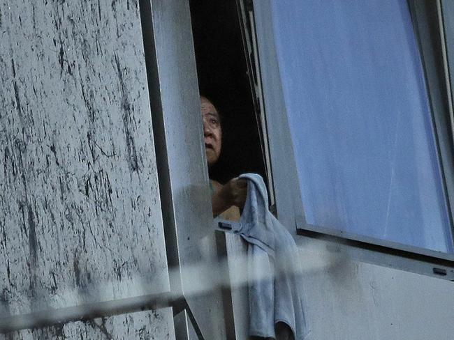 A person peers out of a window from the burning building. Picture: Matt Dunham/AP